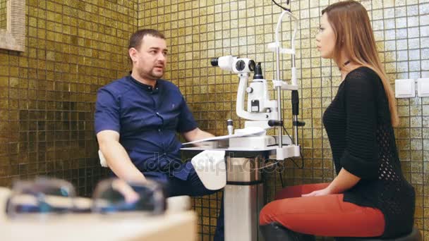 眼科コンセプト - 女性患者に説明して医師検眼室で彼のビジョン — ストック動画