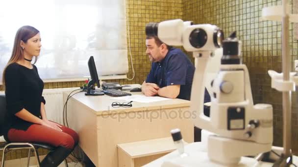 El médico explica al paciente los resultados de los exámenes oftálmicos antes de la cirugía oftalmológica — Vídeo de stock