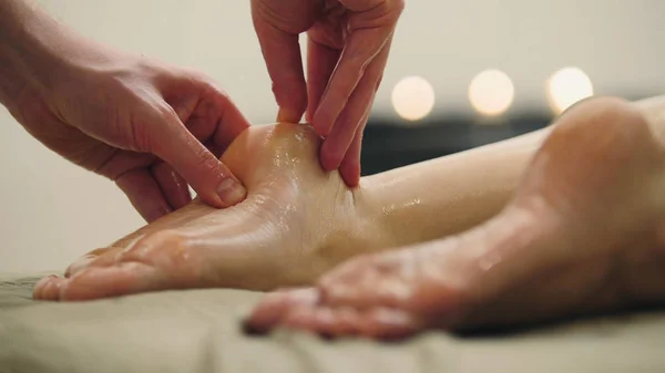 Sesam olie massage voor de voet van de hiel. Ontspanning behandeling voor jonge vrouw, close-up — Stockfoto