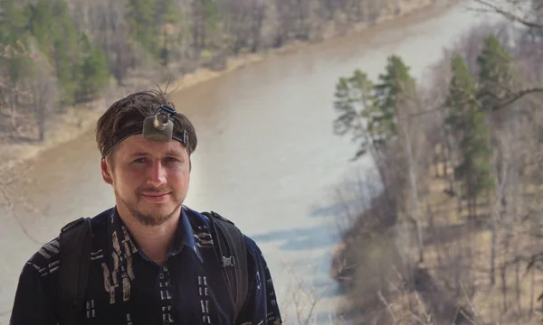 Portret van jonge man staande op hoge heuvel in de buurt van Mount River Cave-zaklamp op het hoofd — Stockfoto