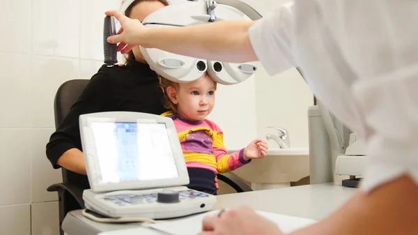 Optometrist in clinic checking little girls vision - childrens ophthalmology — Stock Photo, Image