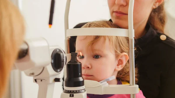 Kindergesundheit - kleines Mädchen mit Mutter in Augenklinik überprüft Sehvermögen — Stockfoto