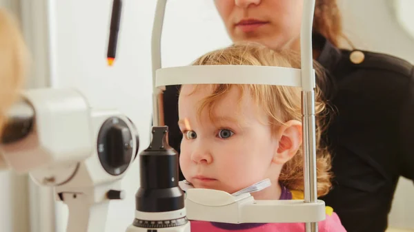 Childs optometri - liten flicka hecks syn i ögat oftalmologisk klinik — Stockfoto
