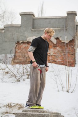 Kış parkta akrobasi-sarışın adam genç Parkour atlamak için hazır-çevirmek