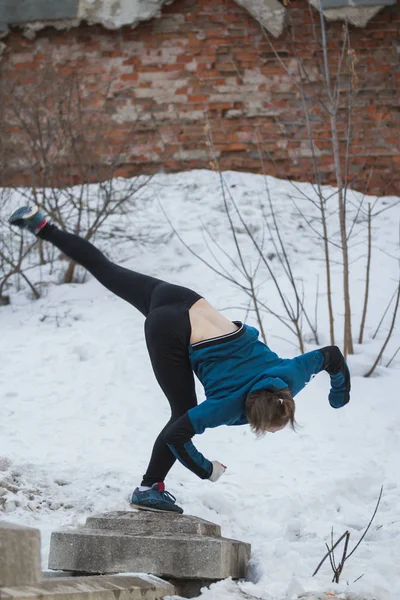 Menina adolescente pulando flip no parque de inverno de neve - conceito de parkour de execução livre — Fotografia de Stock