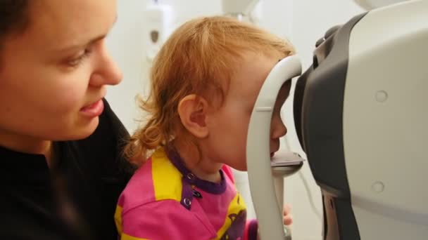 Oftalmología infantil - optometrista comprueba los ojos de los niños — Vídeo de stock