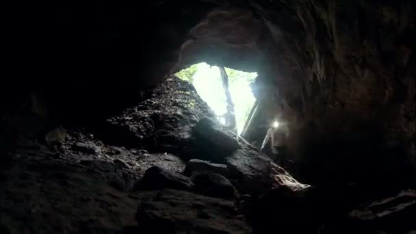 Молодая привлекательная пара входит в пещеру — стоковое видео