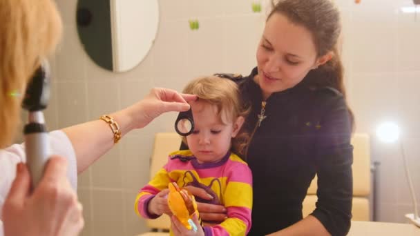 Oftalmología - el médico comprueba la vista a la niña - cuidado de la salud infantil — Vídeo de stock