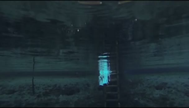 Человек в гидрокостюме ныряет, чтобы очистить озеро - замедленная съемка — стоковое видео