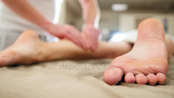 Mladá žena přijímá masáž pro nohy. Relaxační ošetření pro kavkazské model, zblízka — Stock video