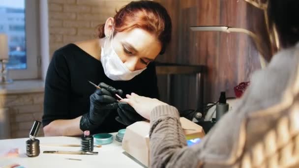 Manikiurzystka Kobieta maski medyczne robi manicure w salonie piękności — Wideo stockowe