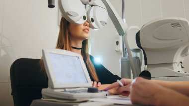 Sarışın genç kadın göz testi optometrist Tıp Merkezi ile yaptıkları