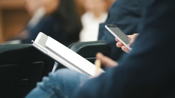 Hombre empleado en traje utiliza dispositivo digital sentado en el foro sobre la industria y la economía — Vídeos de Stock