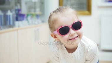 oynama ve bir ayna ve çalışır moda tıbbi gözlük ayna - göz hastalıkları kliniğinde alışveriş yakınındaki önünde Hamming küçük kız