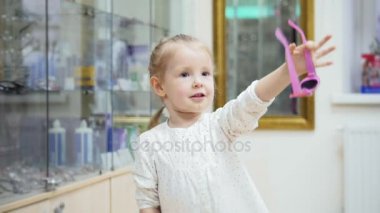 Sevimli sarışın kız dans ve tıbbi klinikte alışveriş mağazası - pembe gözlük satın almak anne sorar
