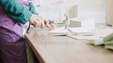 Tipografi - kadında yalan makinesi sektöründe işçilik çekiçle broşürün sayfalarını tamamlar