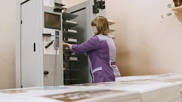 Indústria de polígrafo - mulher trabalhando na máquina de pasta na casa de impressão — Vídeo de Stock