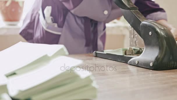 Mujer en tipografía perfora agujeros en la industria del polígrafo de papel de embalaje, mano de obra — Vídeo de stock