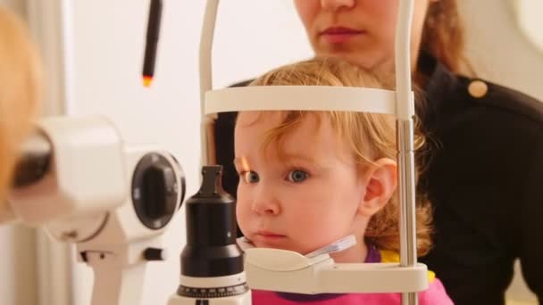 Здоровье детей - офтальмология - врач проверяет зрение у маленькой девочки — стоковое видео