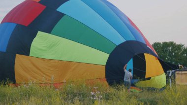 Mürettebat yaz alanında büyük renkli sıcak hava balonu şişirmek