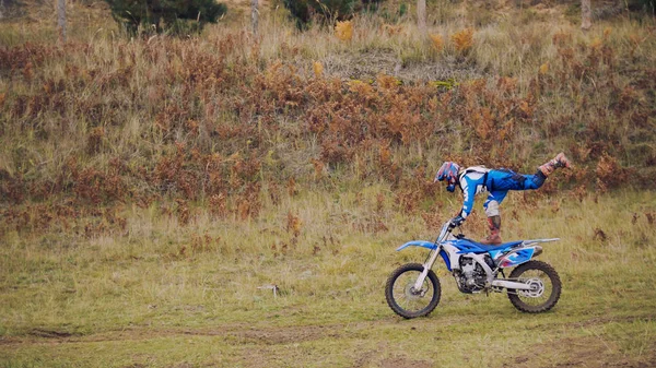 MX moto vrouw Biker toont acrobatische in cross racing - ruiter op een motorfiets vuil — Stockfoto