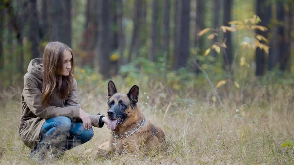 年轻女子在秋天公园，她的宠物-德国牧羊犬 — 图库照片