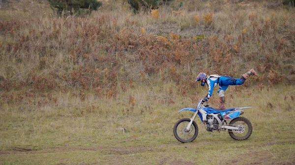 Girl Bike mostra acrobático na moto MX cross racing - piloto em uma motocicleta sujeira — Fotografia de Stock