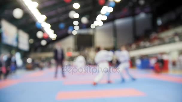 Las karatekas femeninas luchan en competiciones de karate, fondo deportivo desenfocado — Vídeos de Stock