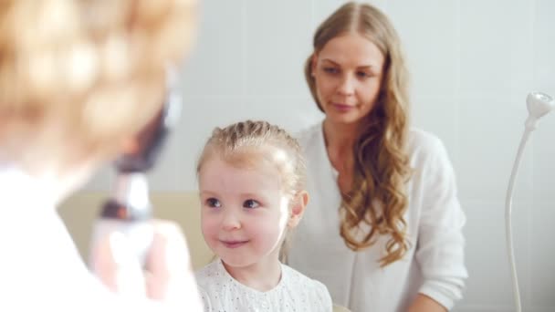 Kinderaugenheilkunde - Untersuchung des Sehvermögens - Diagnose des Augenoptikers kleines Mädchen — Stockvideo