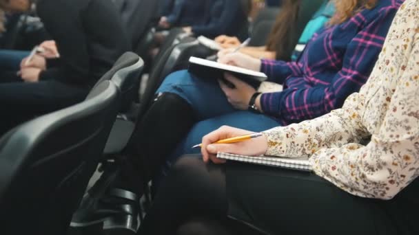 Ouvintes participando de uma palestra - pessoas escrevendo em seus cadernos — Vídeo de Stock