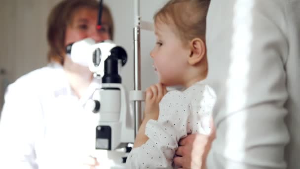 Menina adorável em oftalmologia infantil - optometrista verificando a visão — Vídeo de Stock