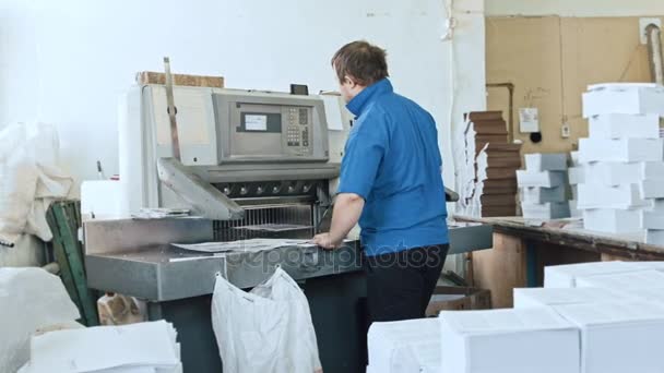 Man voltooit tijdschrift pagina's - handenarbeid - cutter guillotine machine in afdrukken fabriek - typografie — Stockvideo