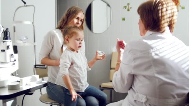 Oftalmolog klinice vysvětluje diagnózu o dívky zrak - matka a dcery zdravotní péče — Stock video