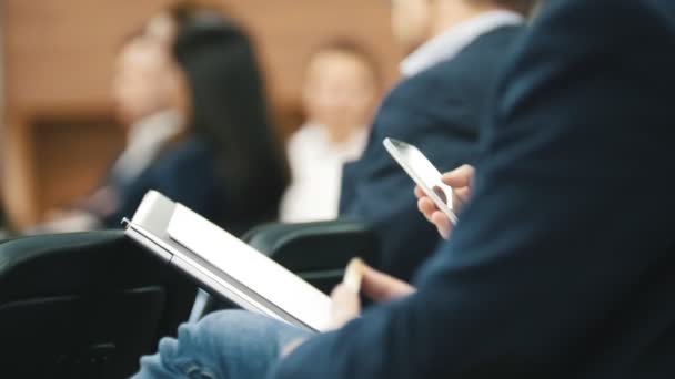 Studenti účastnící se přednášky a dělal poznámky - lidé psát do svých poznámkových bloků — Stock video