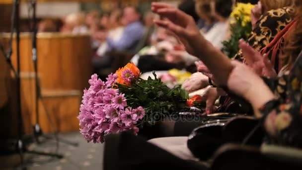 Teatro hal - espectadores con flores aplaudiendo la actuación en el escenario — Vídeos de Stock