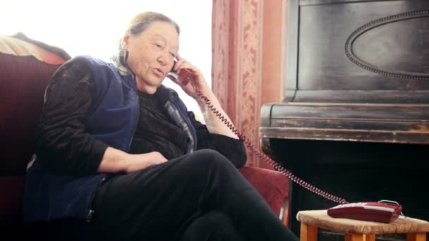 Gammal kvinna pansioner talar fast telefon, vidvinkel — Stockvideo