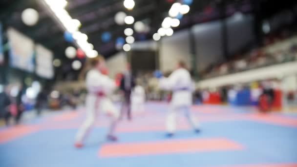 Anak-anak karatekas bertarung di kompetisi karate, gerakan lambat de-fokus latar belakang olahraga — Stok Video