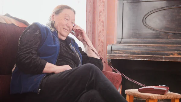 Старуха-пансионка говорит по стационарному телефону, широкий угол — стоковое фото