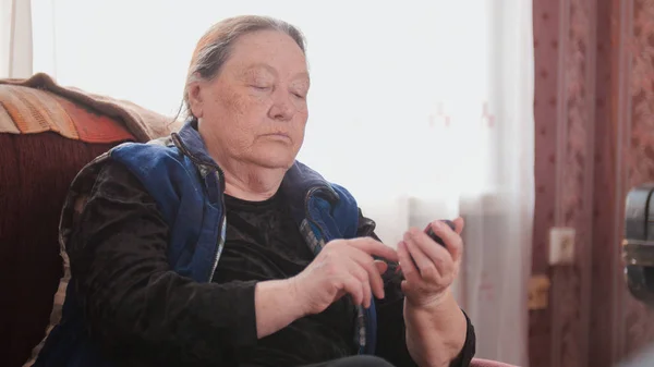 Gammal kvinna pensionär talar på mobiltelefon, teleobjektiv — Stockfoto