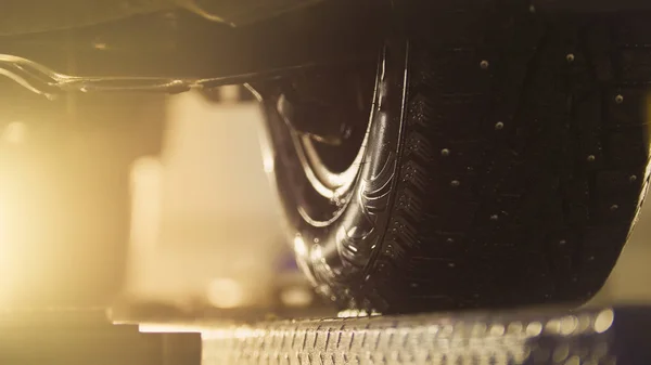 Auto wheel in service, car preparing for professional diagnostics, close up - toned in orange