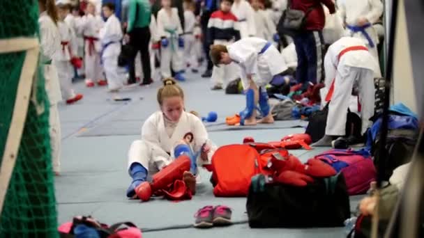 Kazaň, Rusko, 8 dubna 2017, palác singl bojuje proti "Ak pruhy" děti soutěž karate Wkf - karateka sportovec dívka v kimonu nosí červené klapky — Stock video