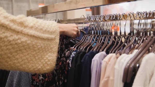 Mujer en una tienda de ropa eligió un vestido - concepto de compras —  Fotos de Stock