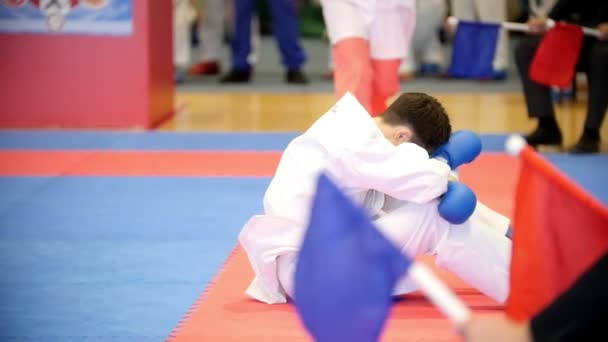 Kazań, Rosja, dnia 8 kwietnia 2017 r., Pałac singla zwalcza konkurencję "Ak Bars" dzieci karate Wkf-nastolatek przykucnął w bólu po walce, lekarz daje mu sole trzeźwiące, zwolnionym tempie — Wideo stockowe