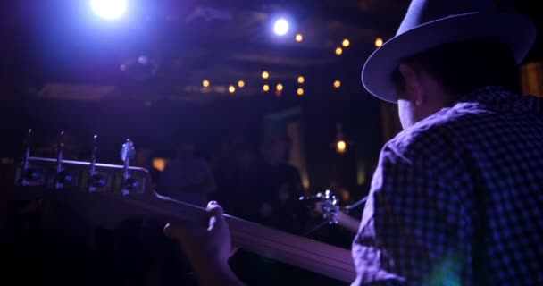 Guitarrista - Músico en sombrero toca la guitarra en el club nocturno, vista trasera — Vídeos de Stock