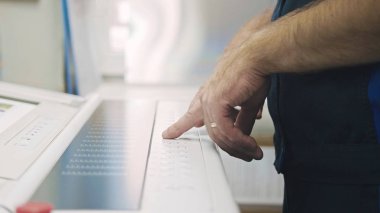 Sanayi işçisi. Kontrol paneli baskı makinesi kullanan adam.