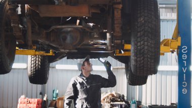 Makinist thr lamba ile Suv araba garaj otomobil Servisi, geniş açı içinde alt kontrol ediyor