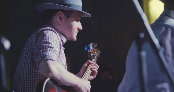 Hudebník v klobouku hraje na kytaru v nočním klubu, zblízka — Stock fotografie