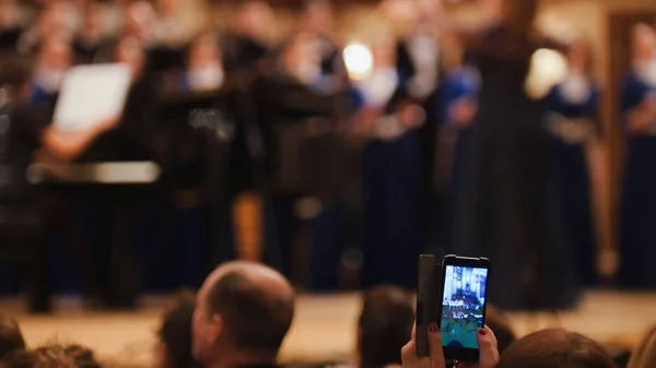 Los espectadores en el concierto - la gente que graba la presentación en el smartphone, la ópera musical —  Fotos de Stock