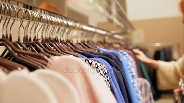 La donna in un negozio di abbigliamento ha scelto un abito - concetto di shopping — Video Stock