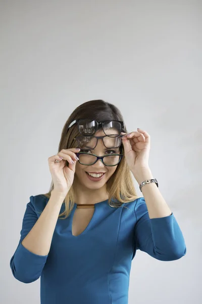 Métaphore ophtalmologique - jeune jolie femme avec trois lunettes sur le visage souriant et regardant vers la caméra — Photo